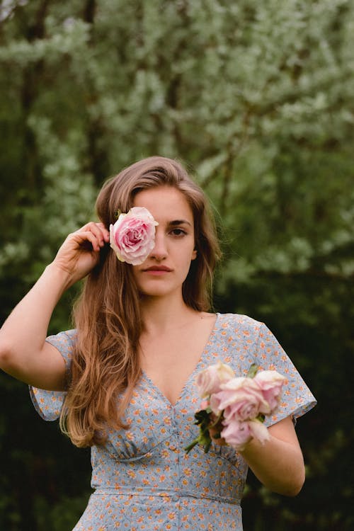 A woman in a blue dress holding roses