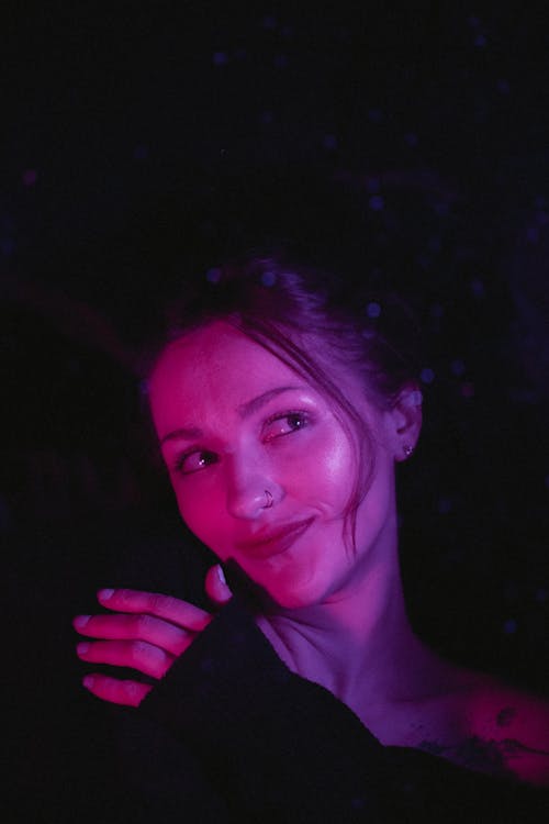 A woman with her arms around her chest in a dark room
