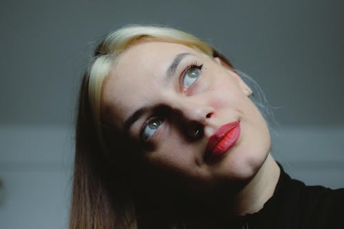 A woman with red lipstick looking up
