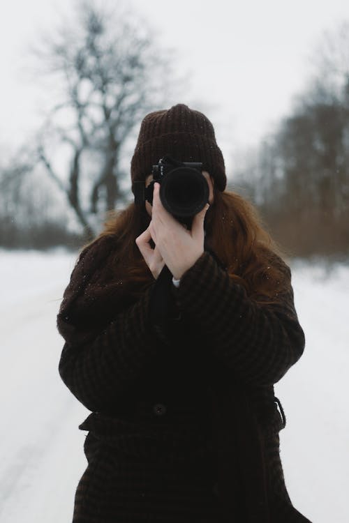 A woman taking a picture in the snow