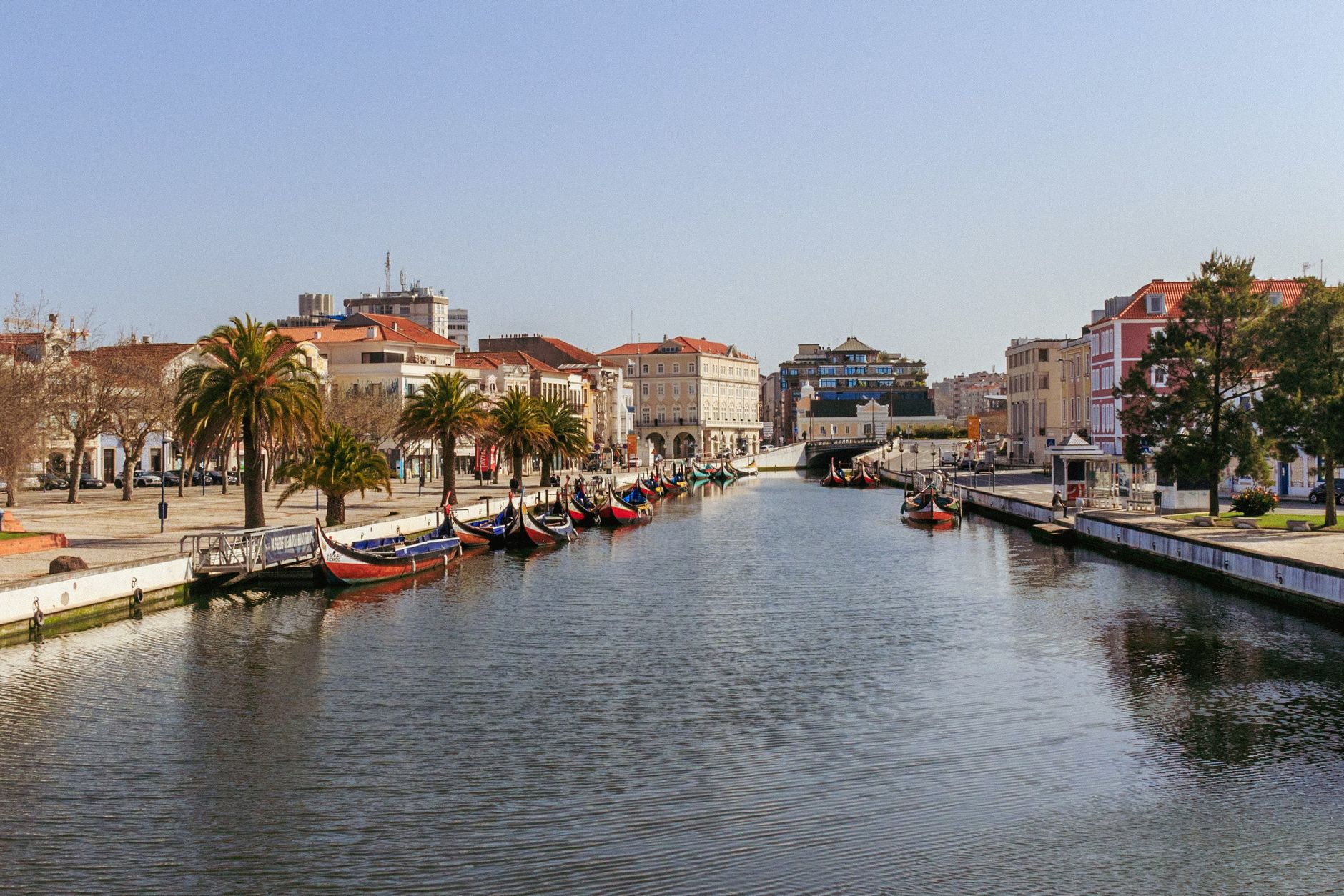 Charming view of Aveiro's central canal with colorful moliceiros and classic architecture along the waterfront.