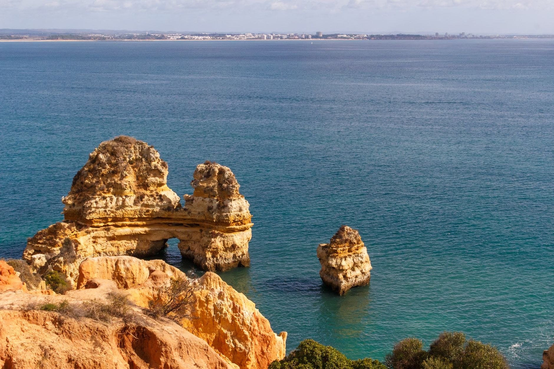 Captivating view of Praia do Camilo's rock formations against the Atlantic Ocean in Lagos, Portugal.