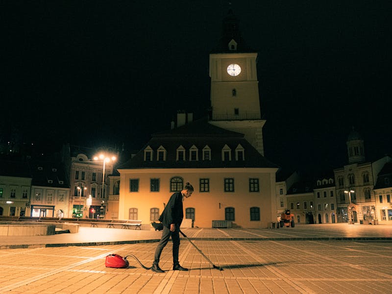 Personne avec un aspirateur sur la place du Conseil à Brașov