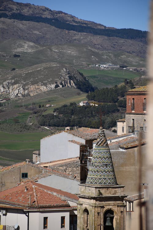 A view of a town with a church tower in the background