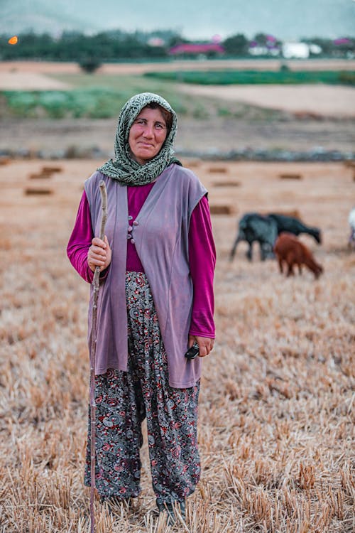 Elderly Woman Standing on Rural Field