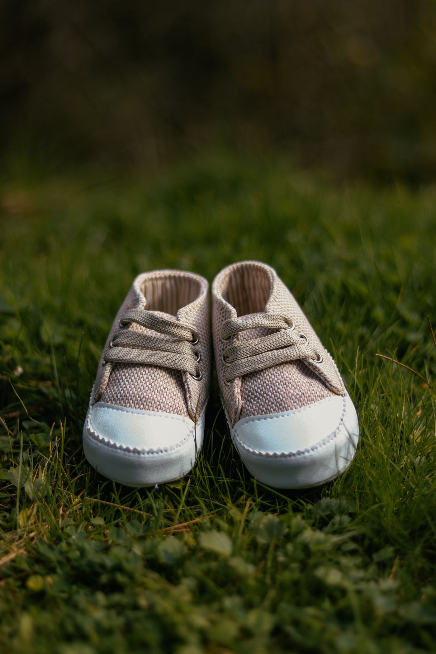 Soft baby shoes resting on green grass