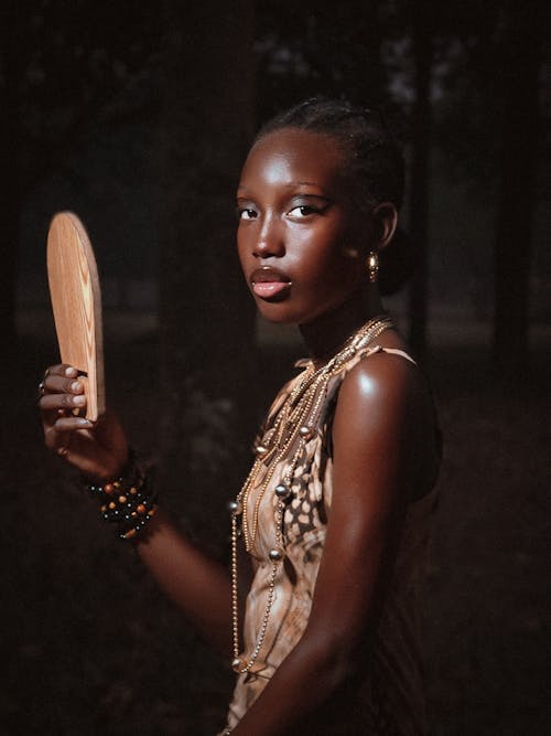 Portrait of Woman in Dress Standing and Holding Wooden Item