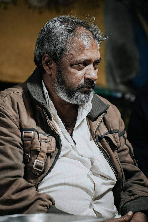 Free Thoughtful elderly man in Srinagar wearing a brown jacket, captured in warm sunlight. Stock Photo