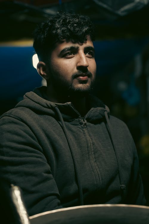 A man in a hoodie is looking at the camera