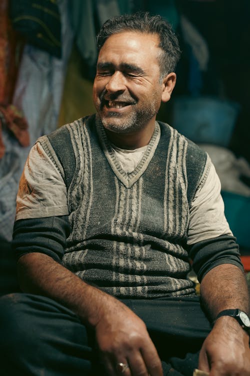 A man sitting in a room with a smile on his face