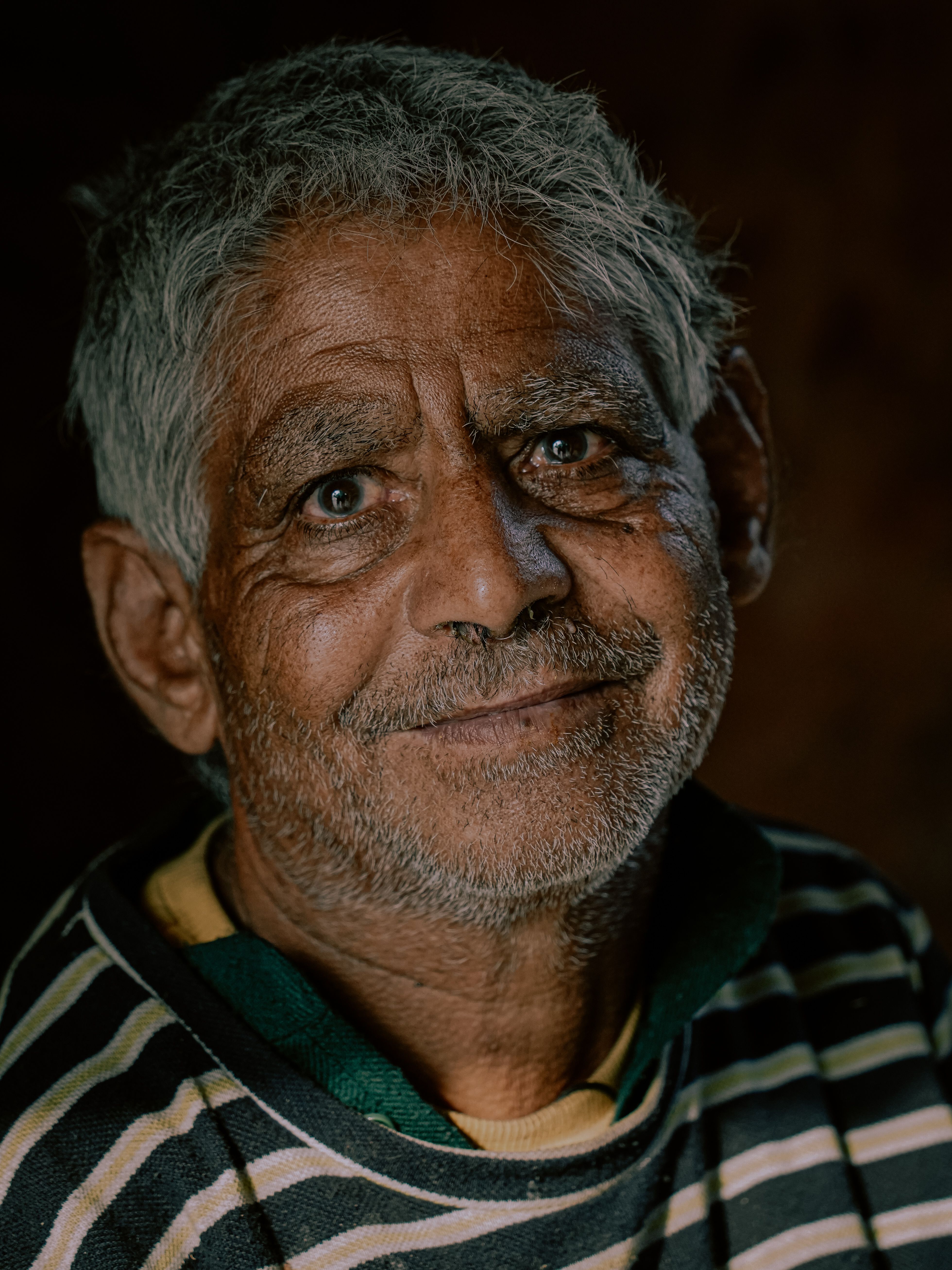 Captivating portrait of an elderly man with a warm smile, captured in Srinagar.