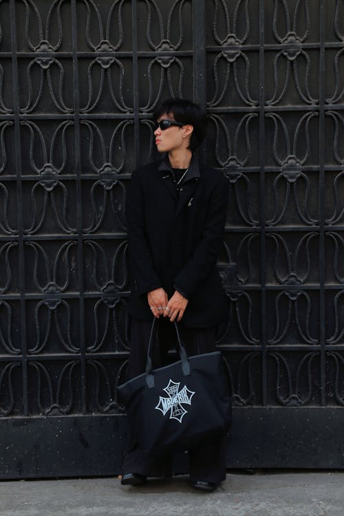 A man in black holding a black bag