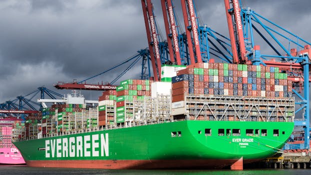 Evergreen cargo ship docked at Terminal Burchardkai, Hamburg under dramatic clouds.