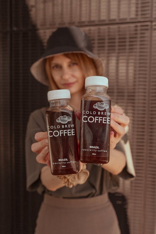 A woman holding two bottles of coffee
