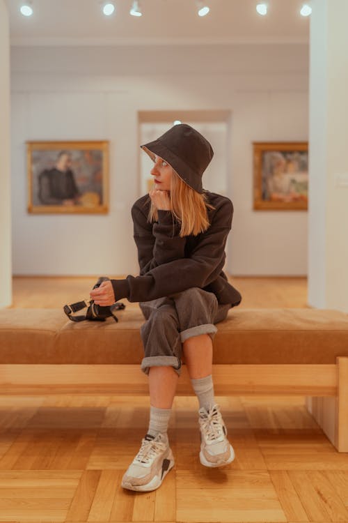 A woman sitting on a bench in an art museum