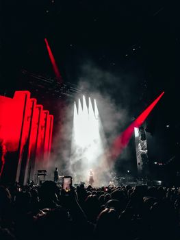 Atmospheric concert in Amsterdam with dramatic lighting and enthusiastic crowd.