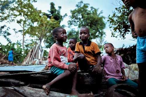 Children sitting on a roof in a village