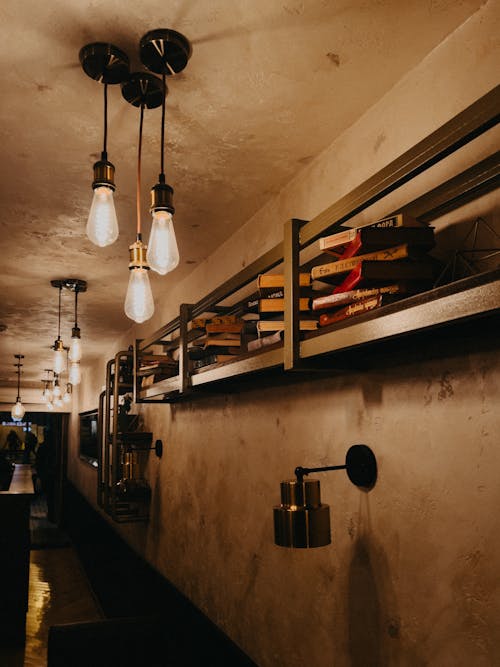 A long bar with light bulbs hanging from the ceiling