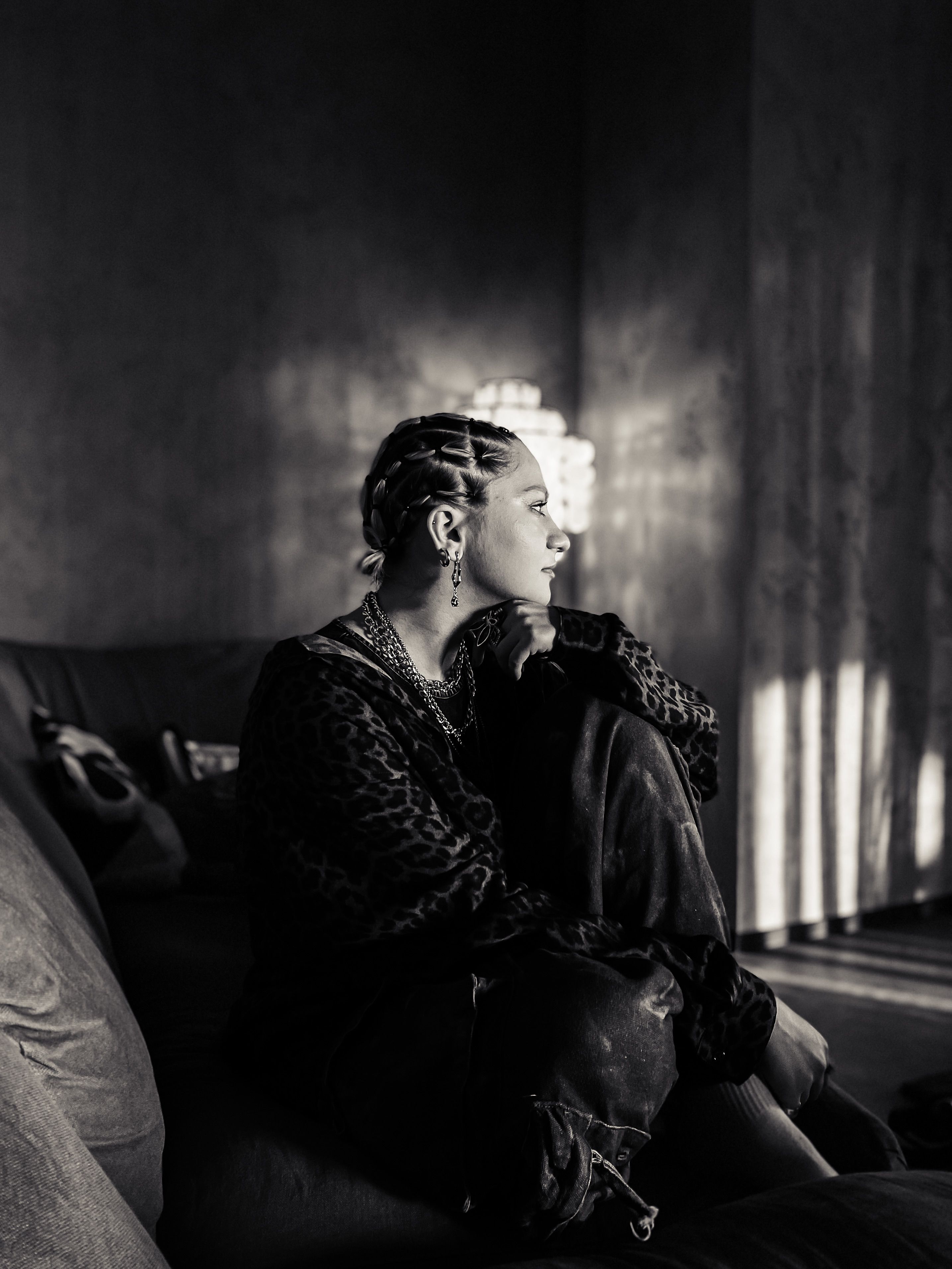 A woman sitting on a couch in a black and white photo · Free Stock Photo