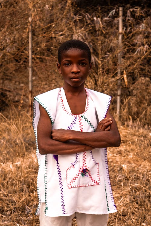 A young african boy standing in a field