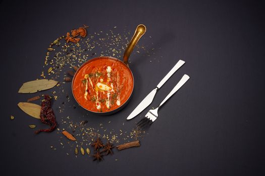 Delicious Indian curry served in a copper frying pan with spices, perfect for a flavorful meal.