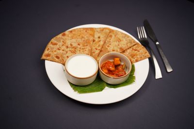 Indian paratha served with pickle and yogurt