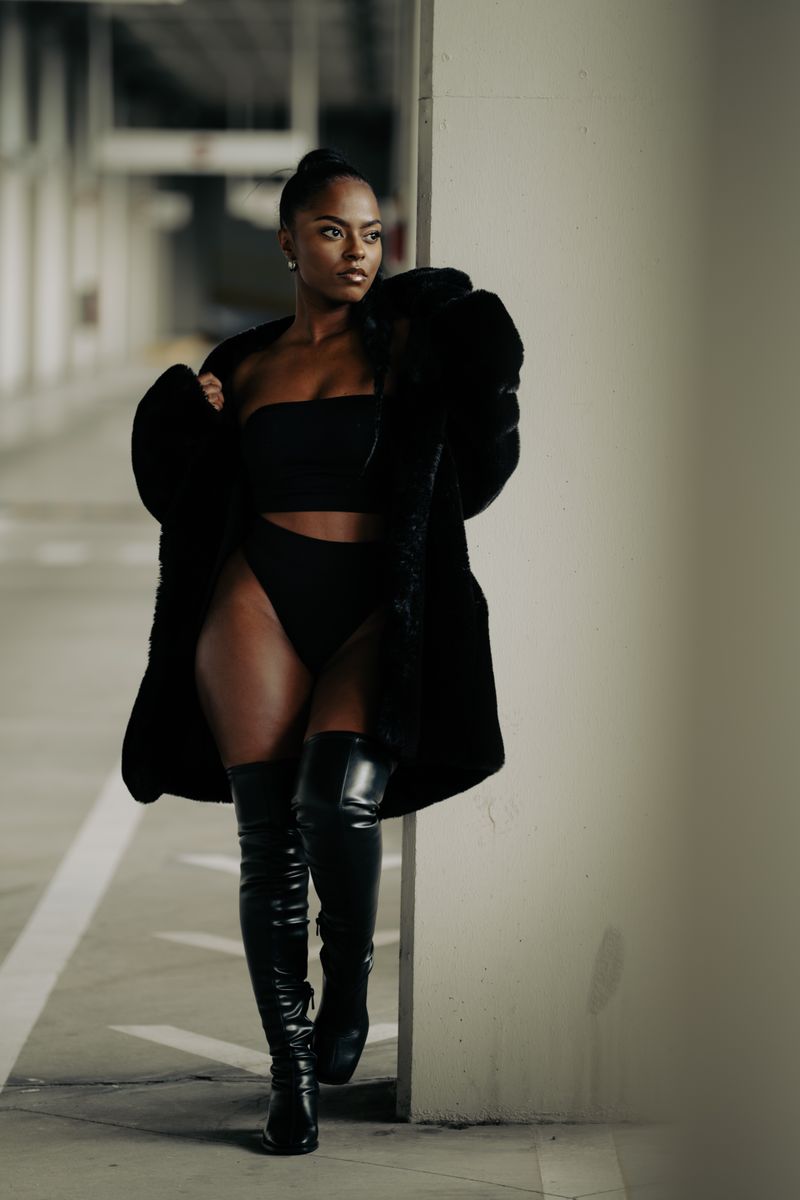 Woman in chic black outfit and boots, urban