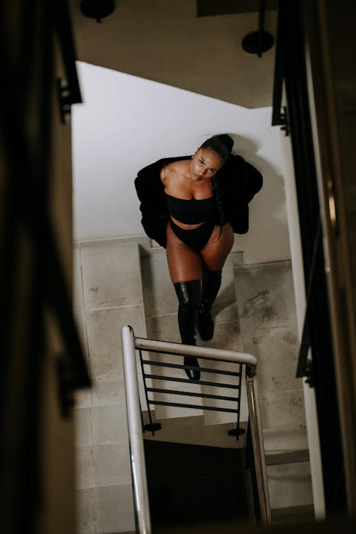 A woman in black underwear standing on a stair