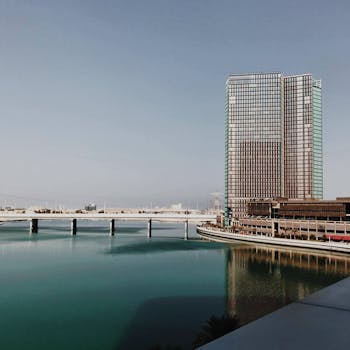 阿布扎比优雅的现代建筑与晴朗的天空一同倒映在平静的水面上