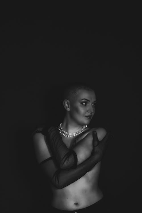 A woman in black and white posing in a dark room