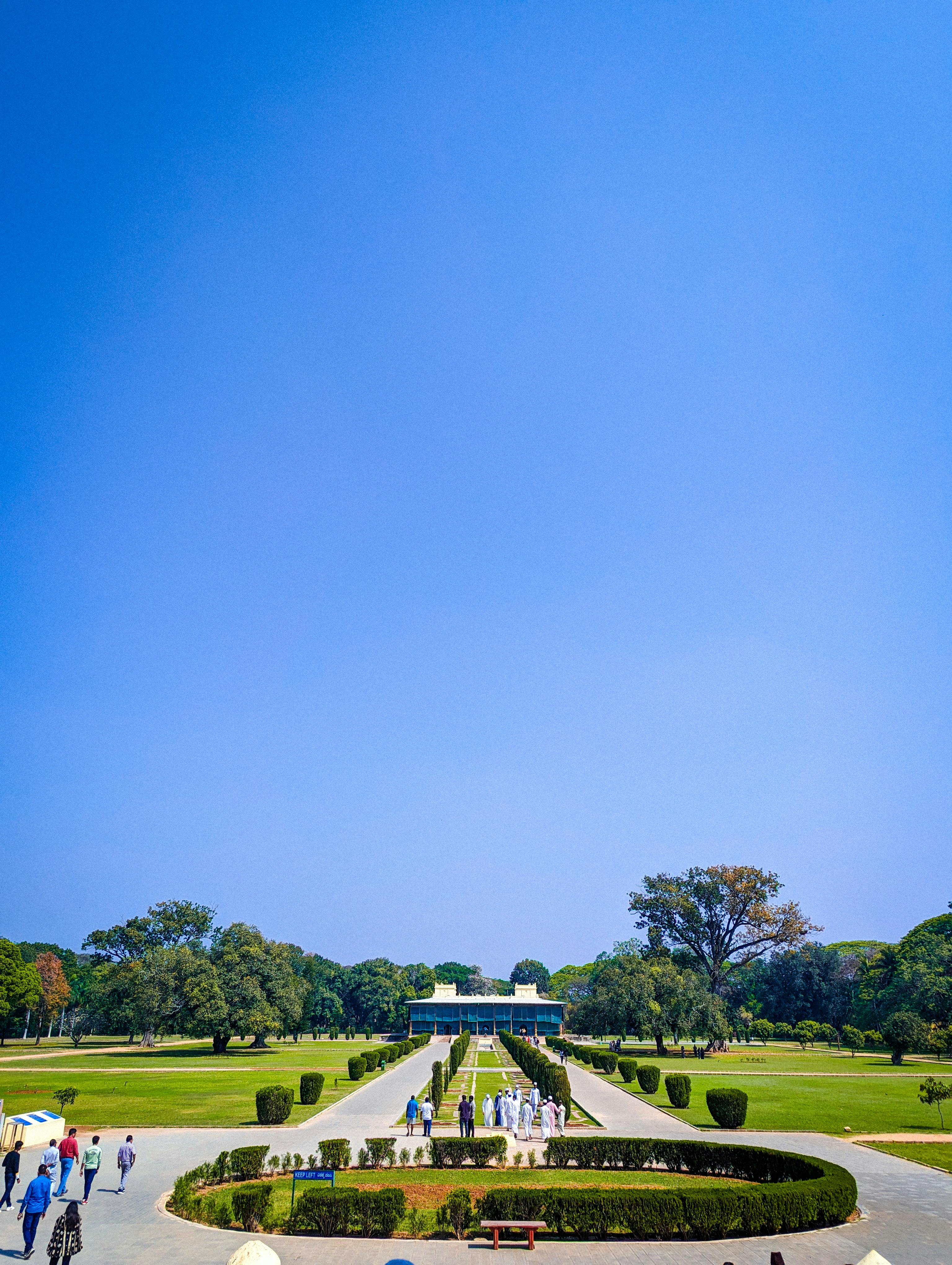 Wide-angle view of Daria Daulat Bagh, showcasing its lush gardens and vibrant blue sky.