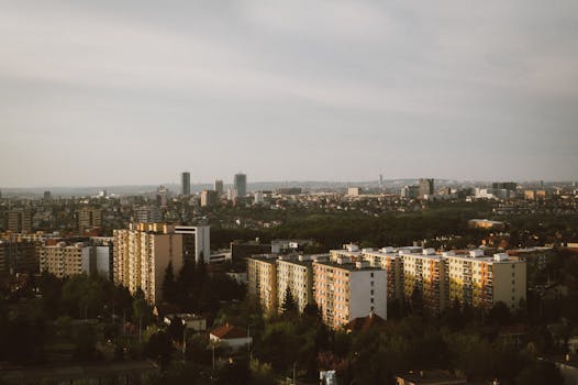 Expansive aerial view of a city's skyline with high-rise buildings and lush greenery.