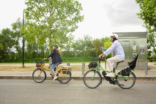 A man and woman cycling through a street in Paris, enjoying an afternoon ride on a tandem bike.