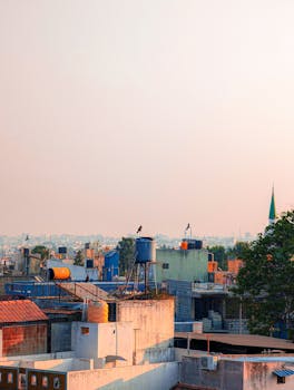 A stunning view of colorful urban rooftops at sunrise, featuring clear skies and cityscape.