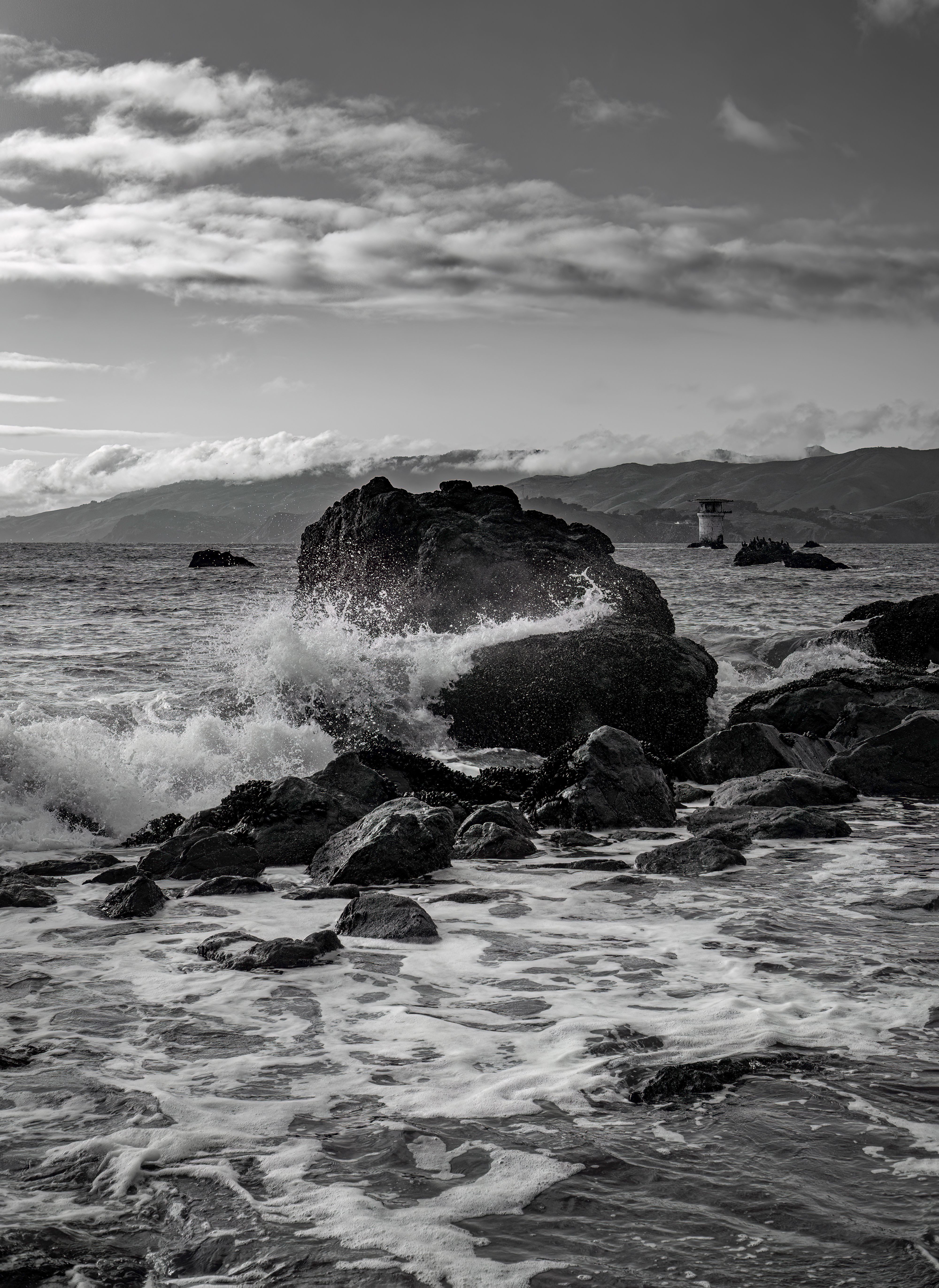 Black and white photograph of waves crashing on rocks · Free Stock Photo