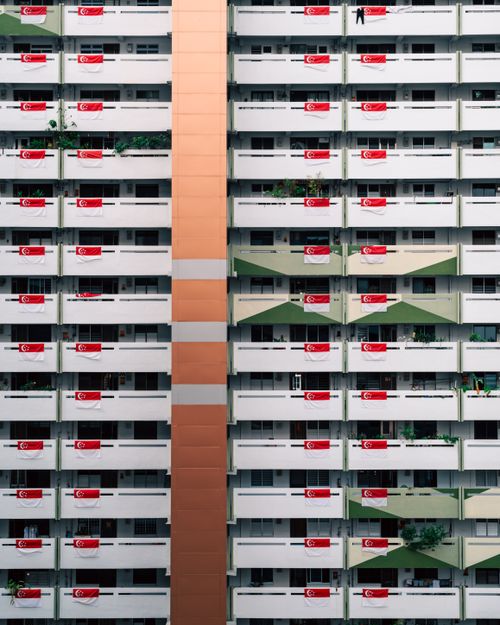 Free High-rise building with Singapore flags on balconies symbolizing national pride. Stock Photo