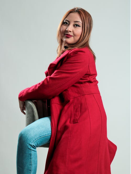 Woman in Red Coat Sitting on Chair