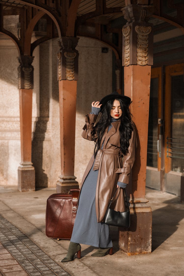 Brunette In Leather Coat With Suitcase At Railway Station