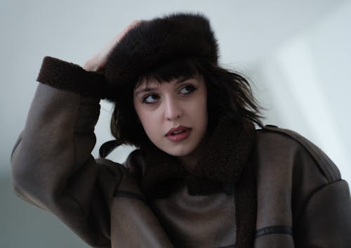 A woman in a brown coat and hat