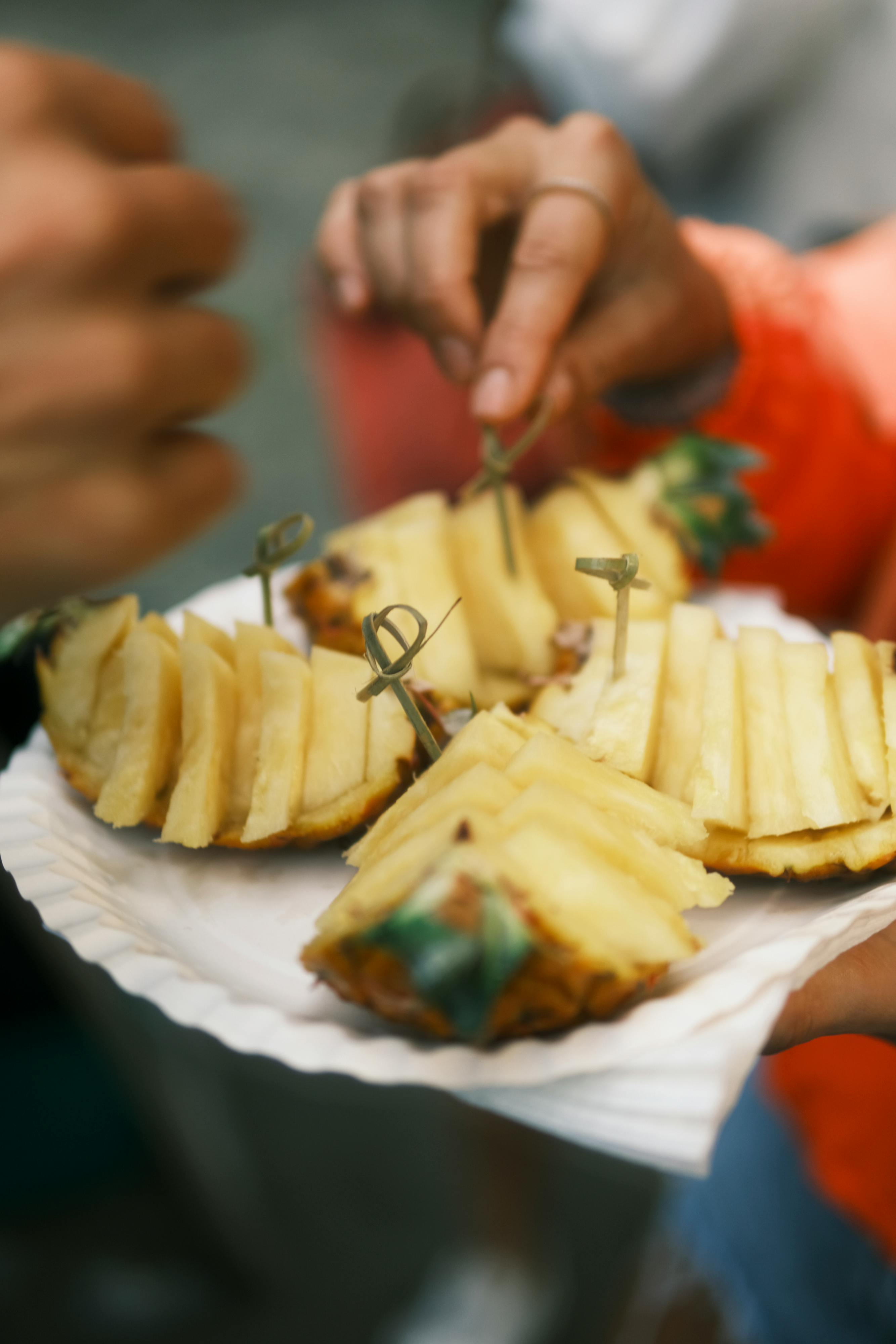 Close-up of fresh pineapple slices served on a paper plate outdoors in Azores.