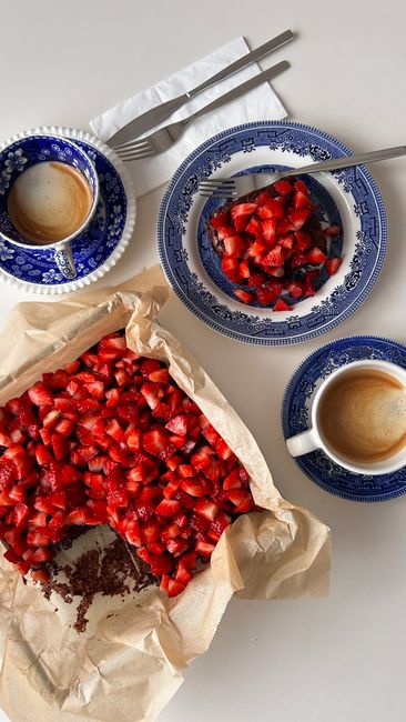 Indulge in a delicious strawberry tart paired with espresso, beautifully arranged on a classic white setting.