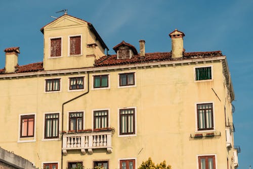 A yellow building with windows and balconies