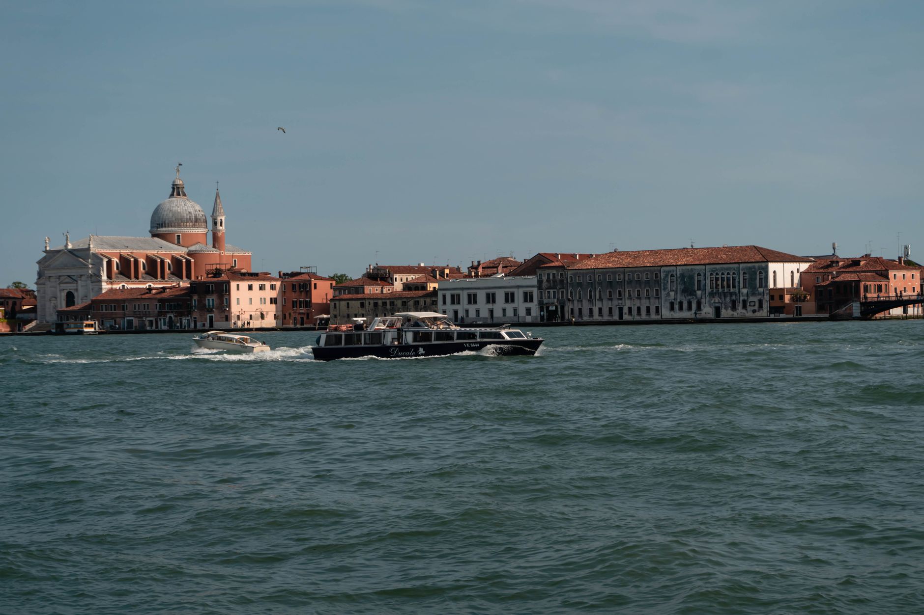 Beautiful Venice cityscape featuring a motorboat on the canal with historic architecture in the background.