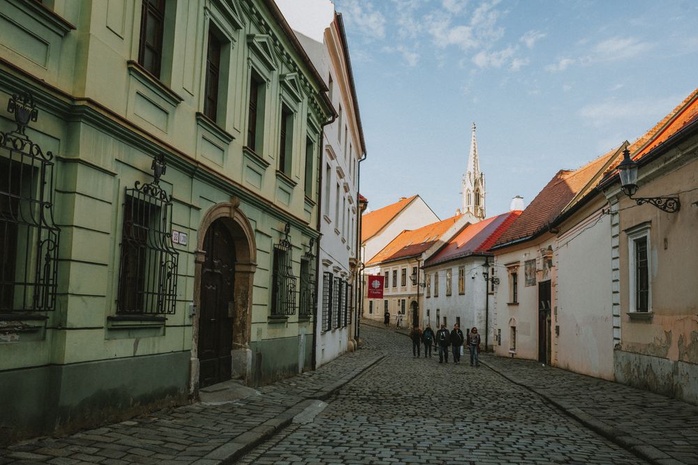 Stradă pavată din orașul vechi al Bratislavei, cu clădiri istorice de o parte și de alta