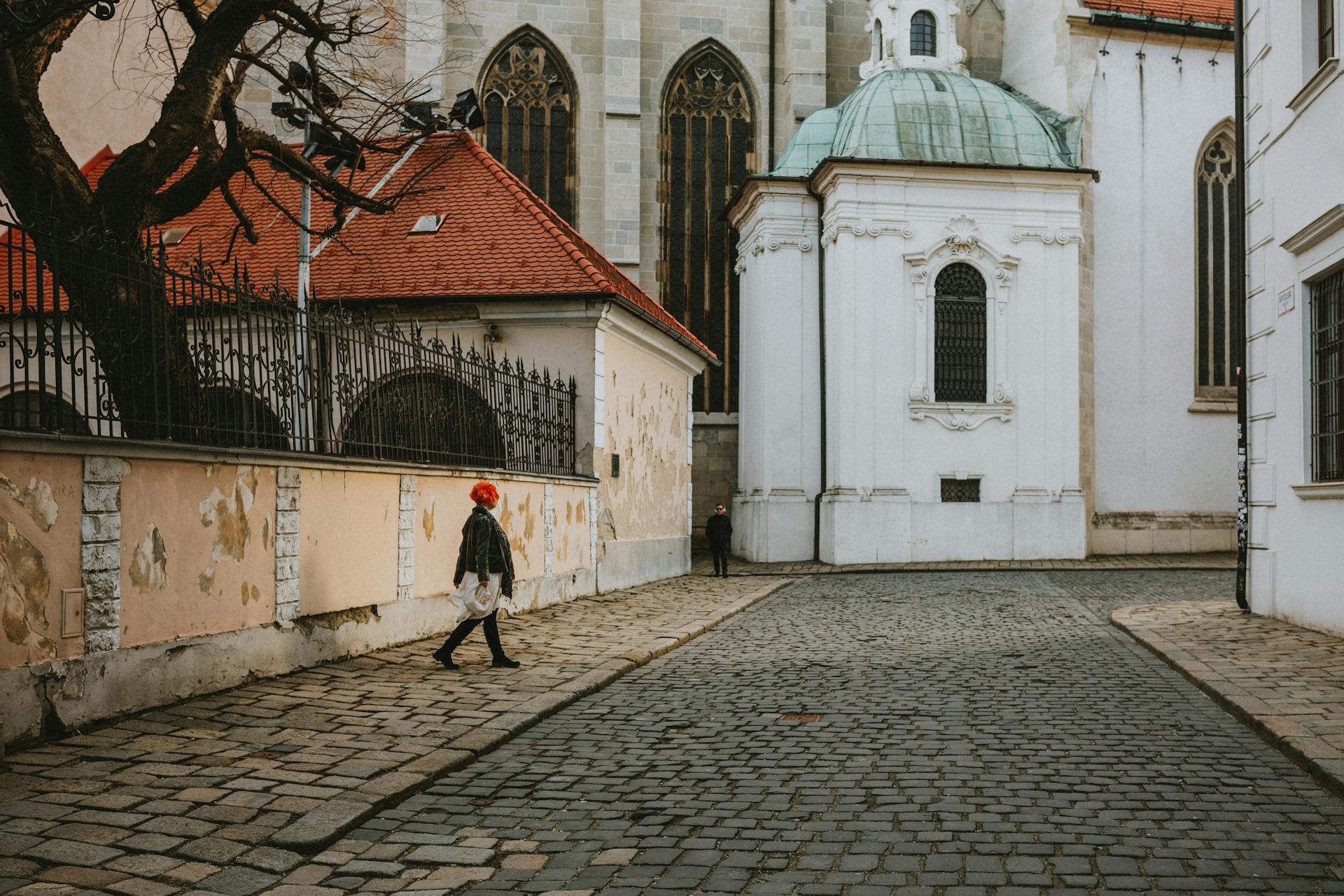 Person Walking on Cobblestone Pavement next to St Martins Cathedral in Bratislava in Slovakia