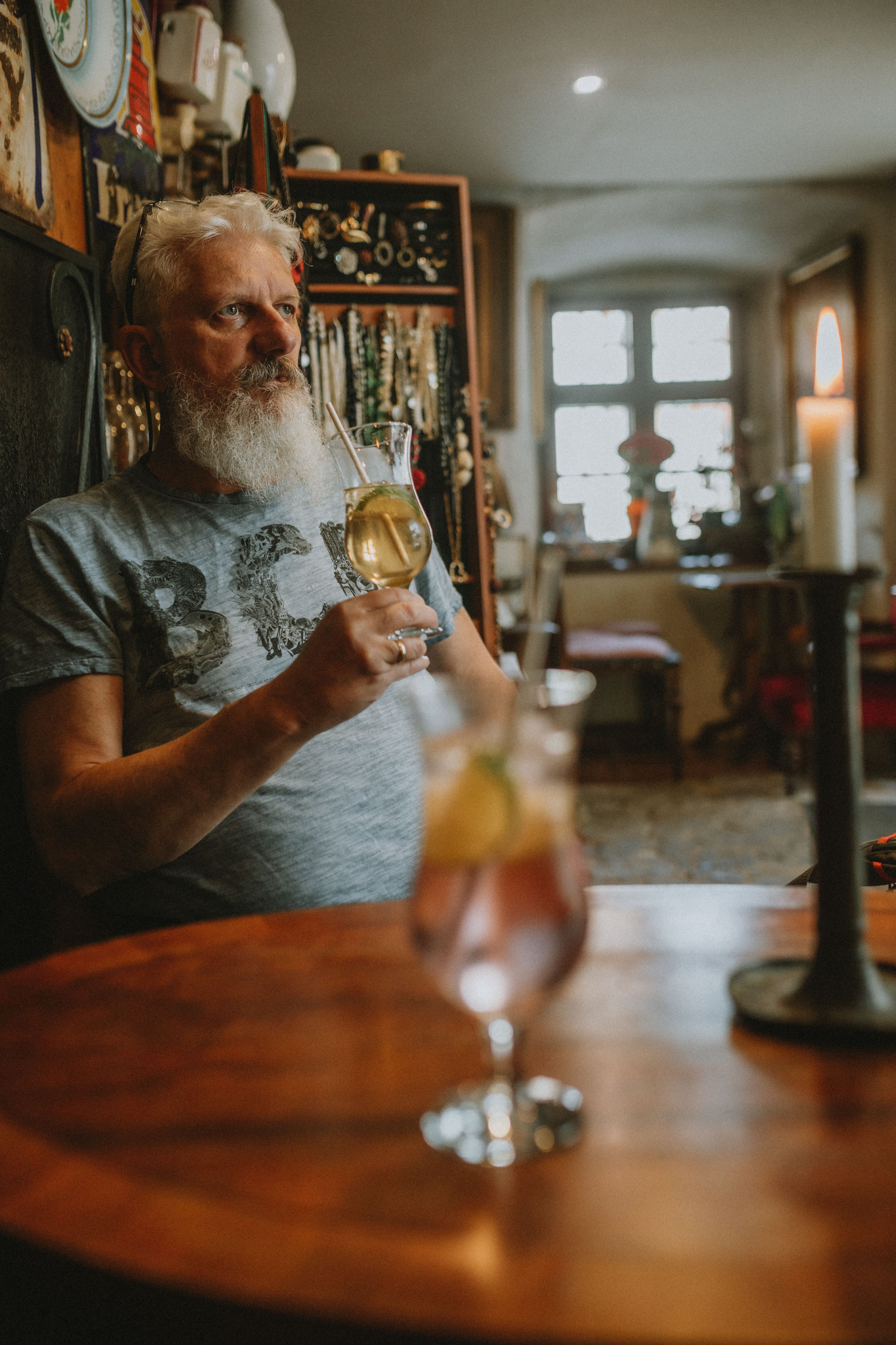 Bearded man enjoying white wine in a cozy indoor setting, depicting leisure.
