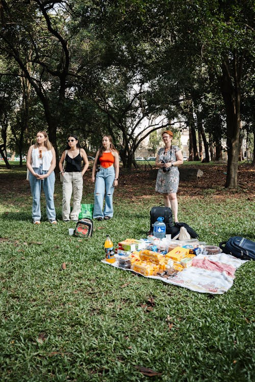A group of people standing in a park with food