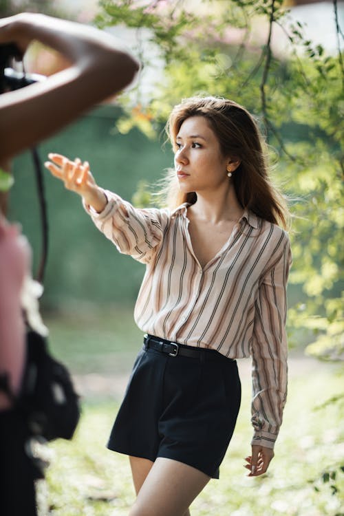 A woman is taking a picture of a woman in the woods