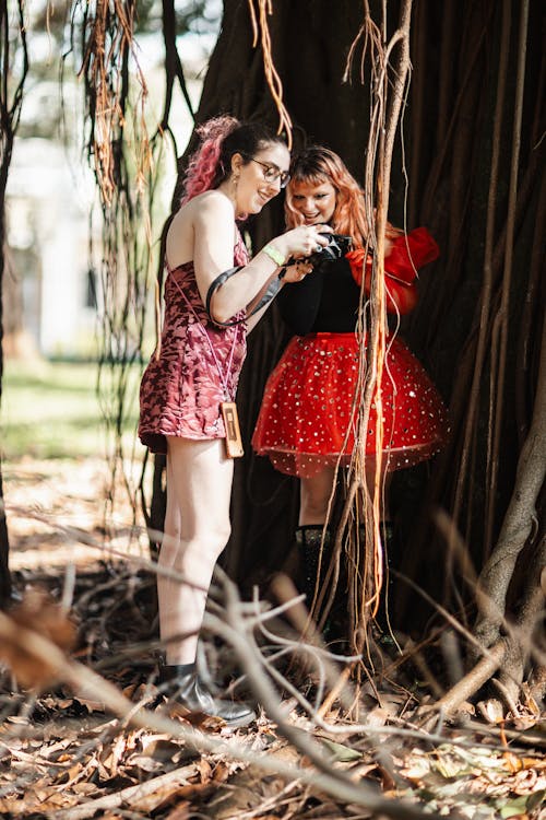 Two women in costumes standing in a tree