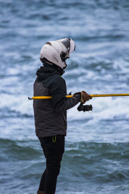 A person in a helmet holding a fishing pole